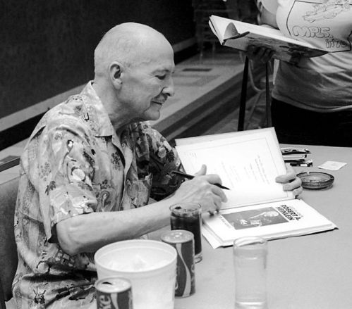 Novelist Robert A. Heinlein autographing one of his works.