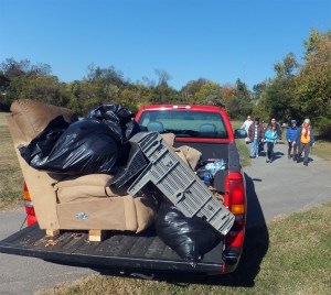 Sofa and TV in back of the truck with cleanup crew on the way to help unload into the dumpster.