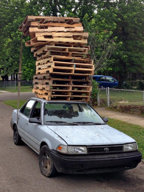 A stack of pallets that would be taller than the car if placed beside it.